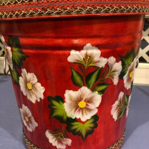 A red can with pink flowers and braided can cover