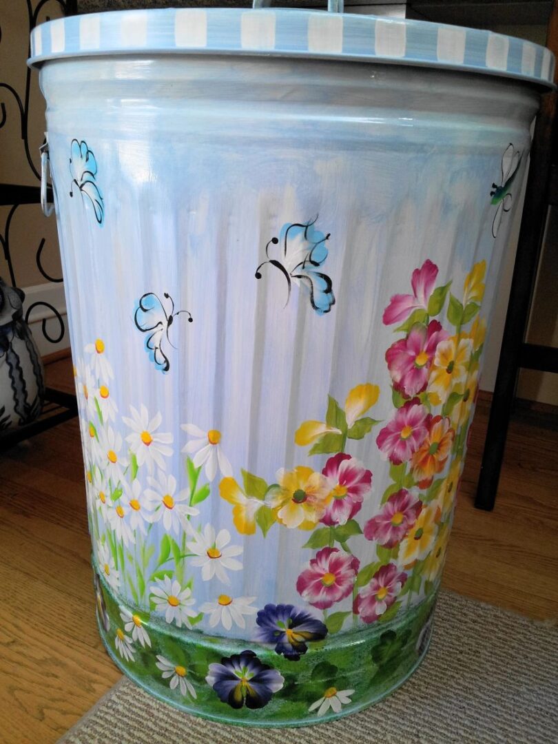A can with light blue butterflies and pink, yellow, and white flowers