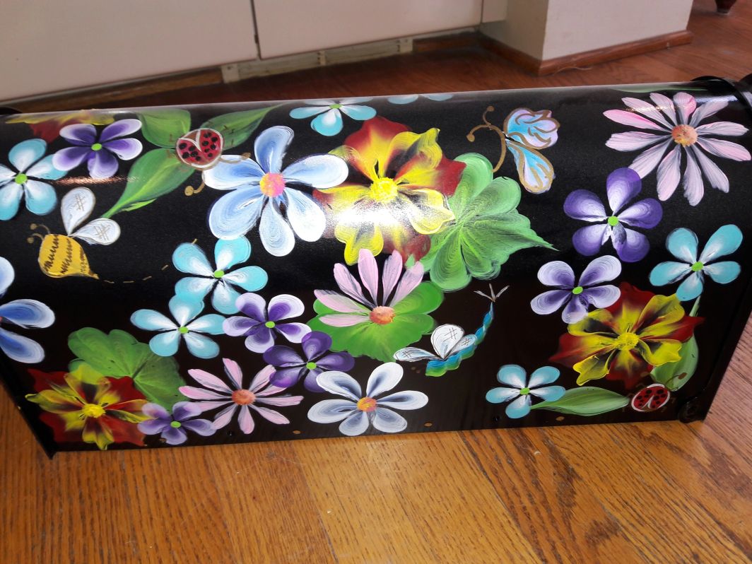 Mailbox black with bright multi color flowers. The Painted Can