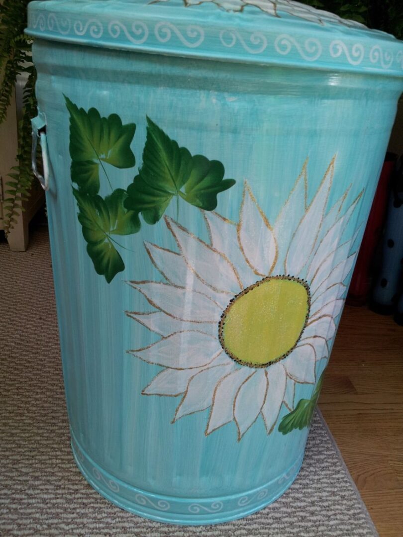 A light blue can with huge white flower and three green leaves