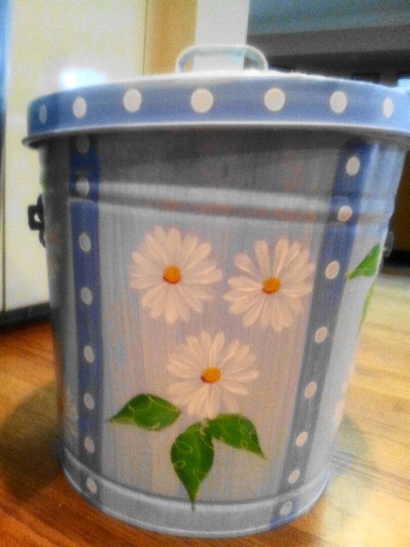 A light blue can with white polka dots and white flowers