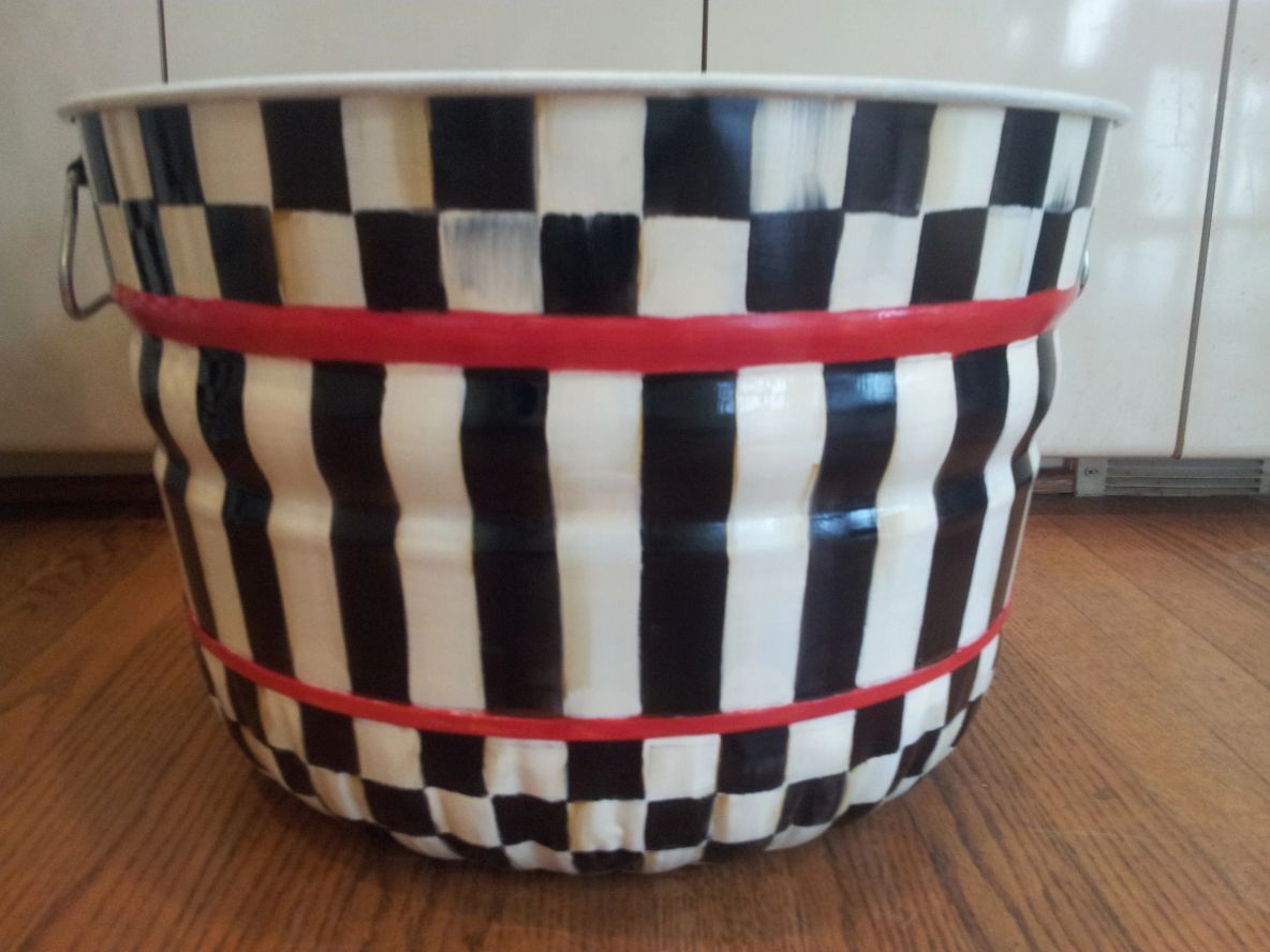 A small can with black and white stripes and boxes patterns and red lines