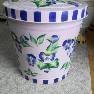 A white can with blue details and flowers
