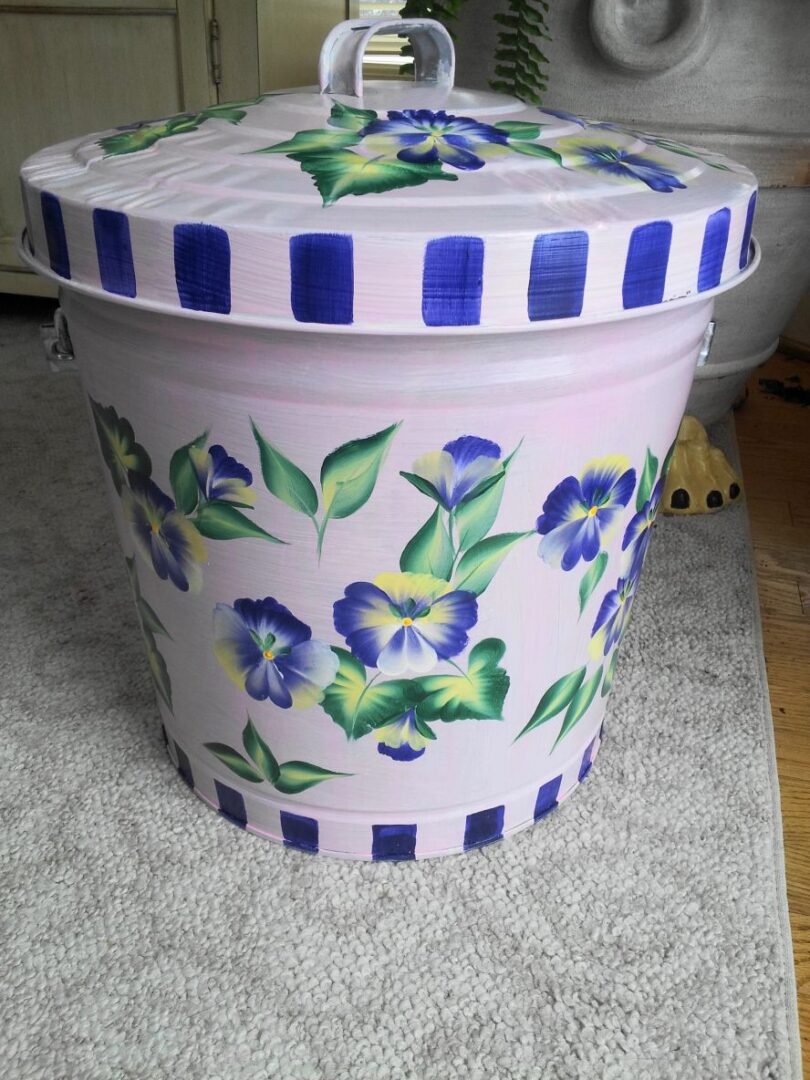 A white can with blue details and flowers