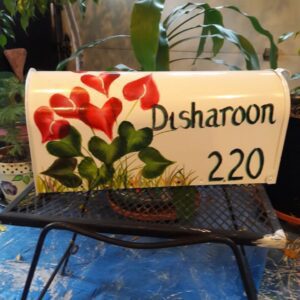 A white mailbox with red flowers and Disharoon 220 label